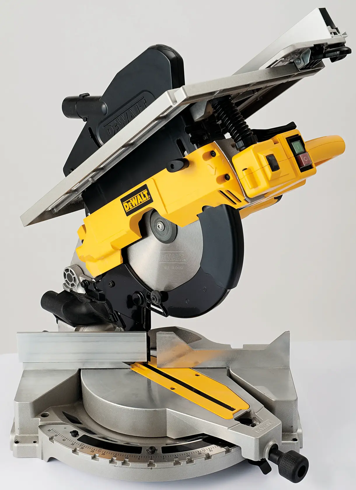 DEWALT D27113 combination mitre saw and table saw in yellow and black, shown in a studio setting with the blade and adjustable fence visible.