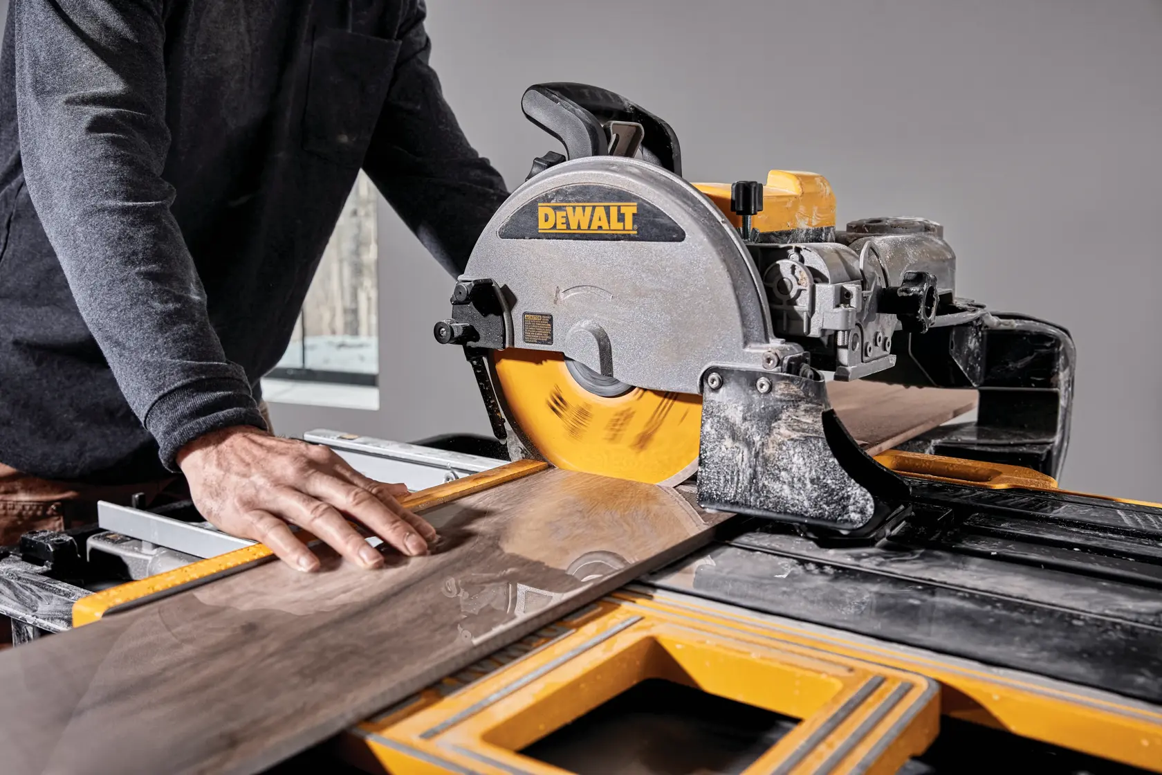 Photo of DEWALT tile saw D36000-QS, D36000 cutting wood, close-up in use, yellow and black design.