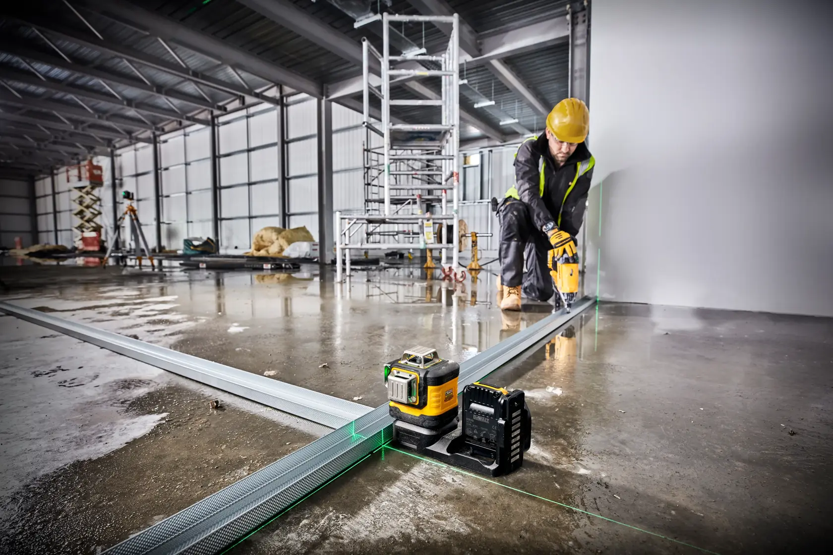 DEWALT grünes Laserwerkzeug auf Baustelle für präzise Ausrichtung von Metallschienen.