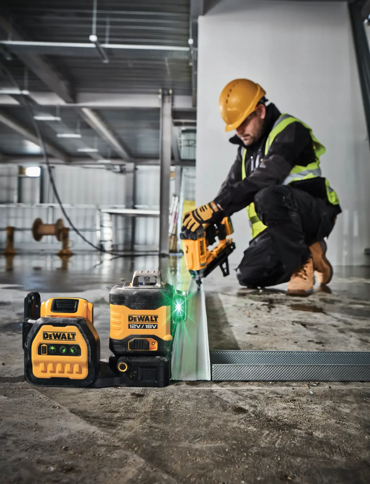 DEWALT DCE089NG18 Laser und Werkzeug auf Baustelle, Arbeiter installiert Metallrahmen.