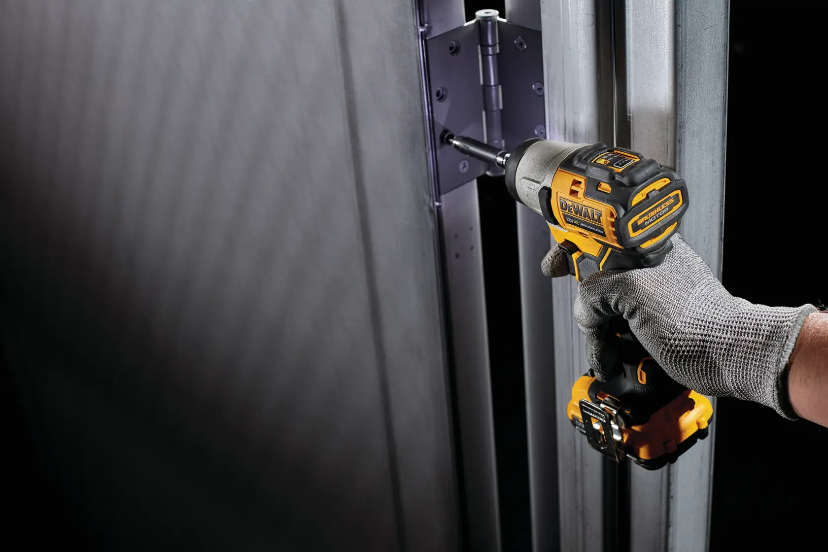 DEWALT DCK2111L2T-XE y DCF801N usado en bisagra de puerta metálica. Imagen de fotografía.