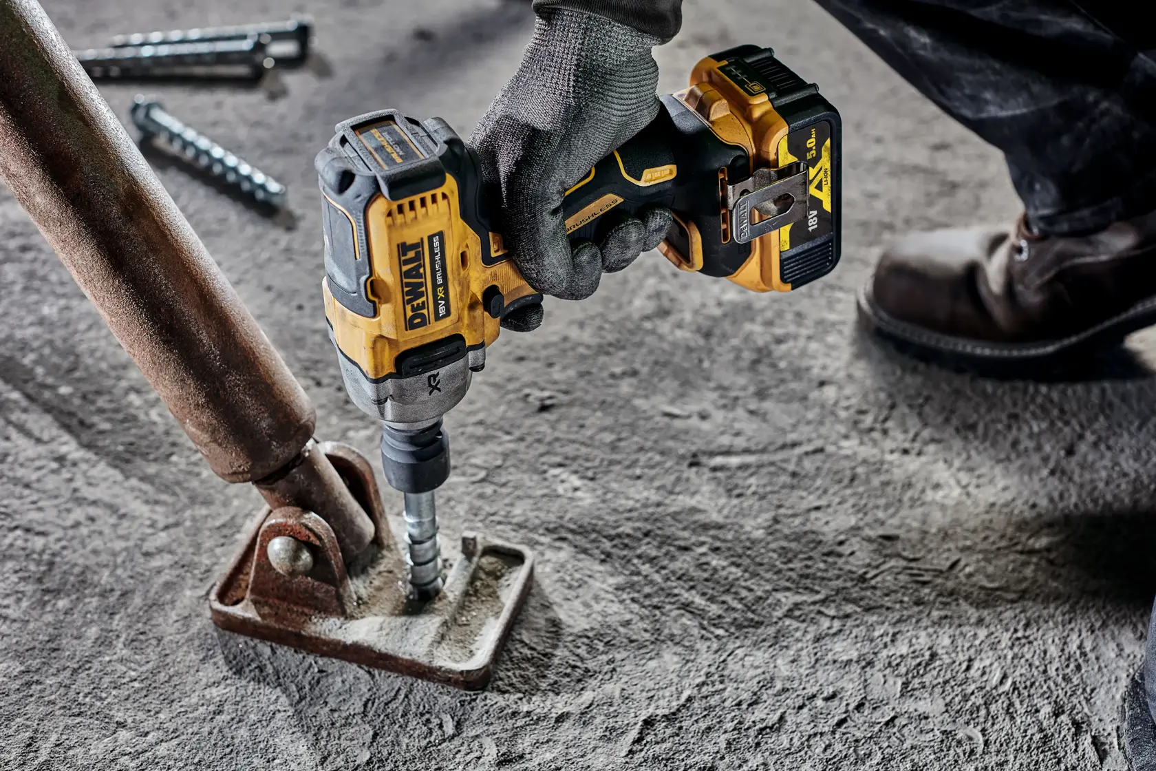 DEWALT Akku-Schlagschrauber befestigt Metall an Beton in einer Industrieumgebung.