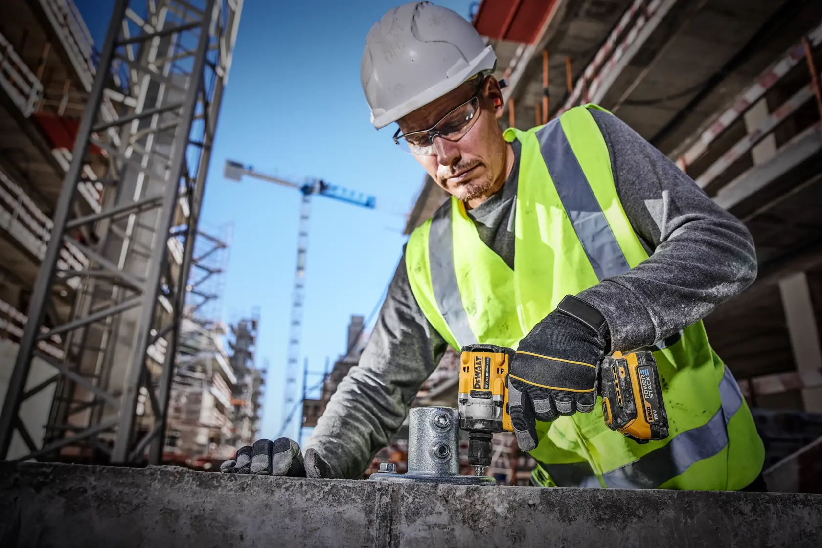 DEWALT DCF921E2T kit including a compact cordless impact wrench, two Powerstack 18V batteries, a battery charger, and a black and yellow DEWALT hard carrying case.