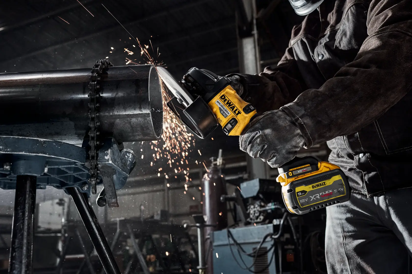 Persona corta tubo de metal con amoladora DEWALT inalámbrica, saltan chispas en taller.