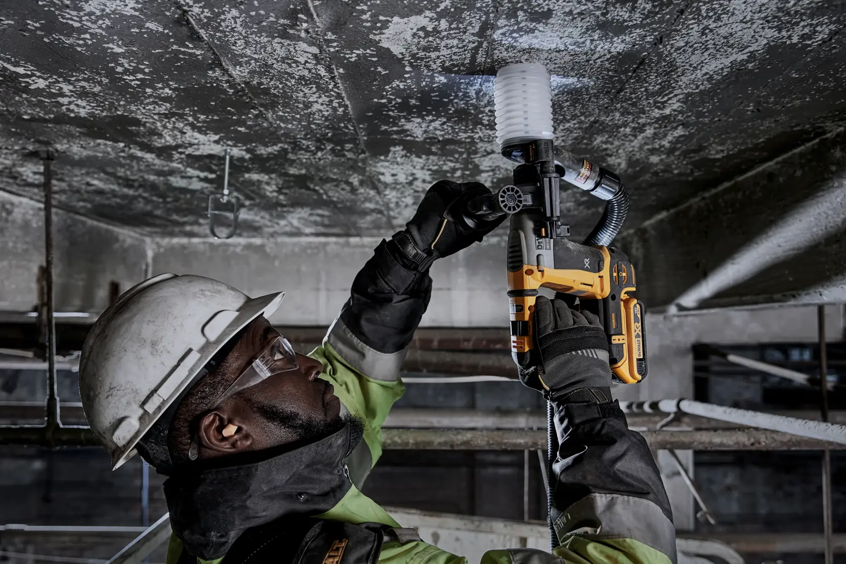Arbeiter nutzt DEWALT DCH172NT-XJ, DCH172NT an der Decke. Industrielle Umgebung, Schutzkleidung.