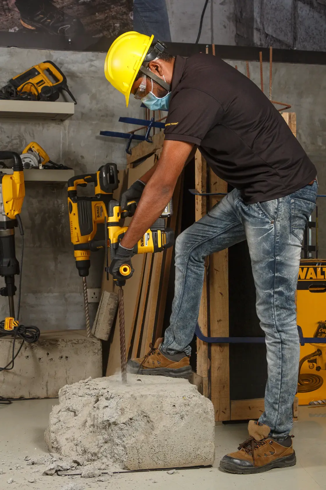 Trabajador taladra bloque de cemento con DEWALT DCH333NT. Usa equipo de seguridad en taller.