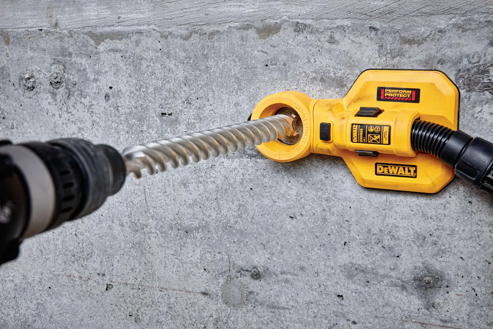 DEWALT-Bohrmaschine mit Staubabsaugung im Einsatz an Betonwand.