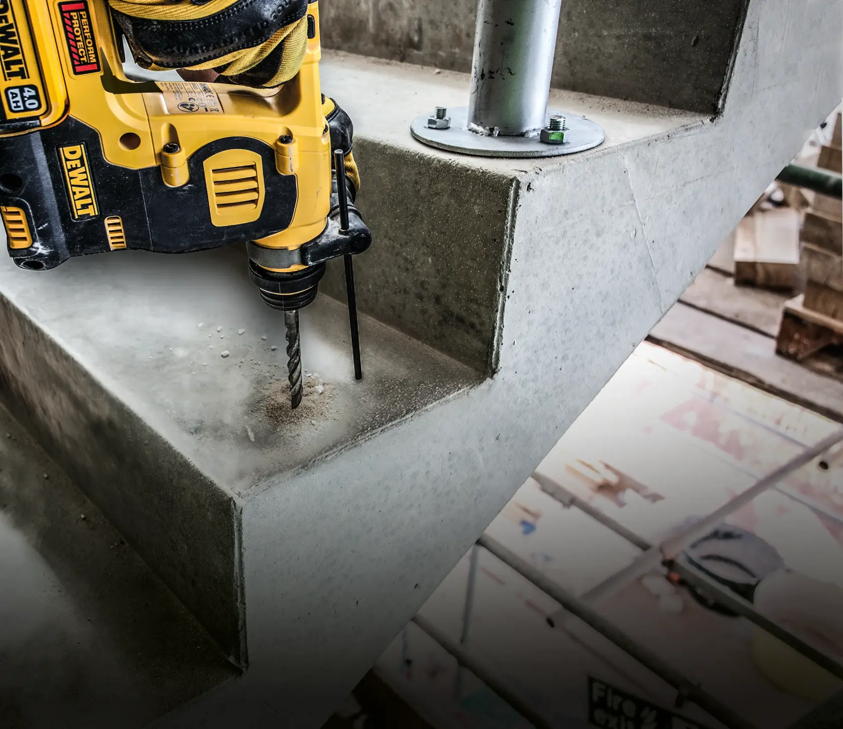 Taladro DEWALT perforando escalera de concreto en obra, polvo visible alrededor de la broca.