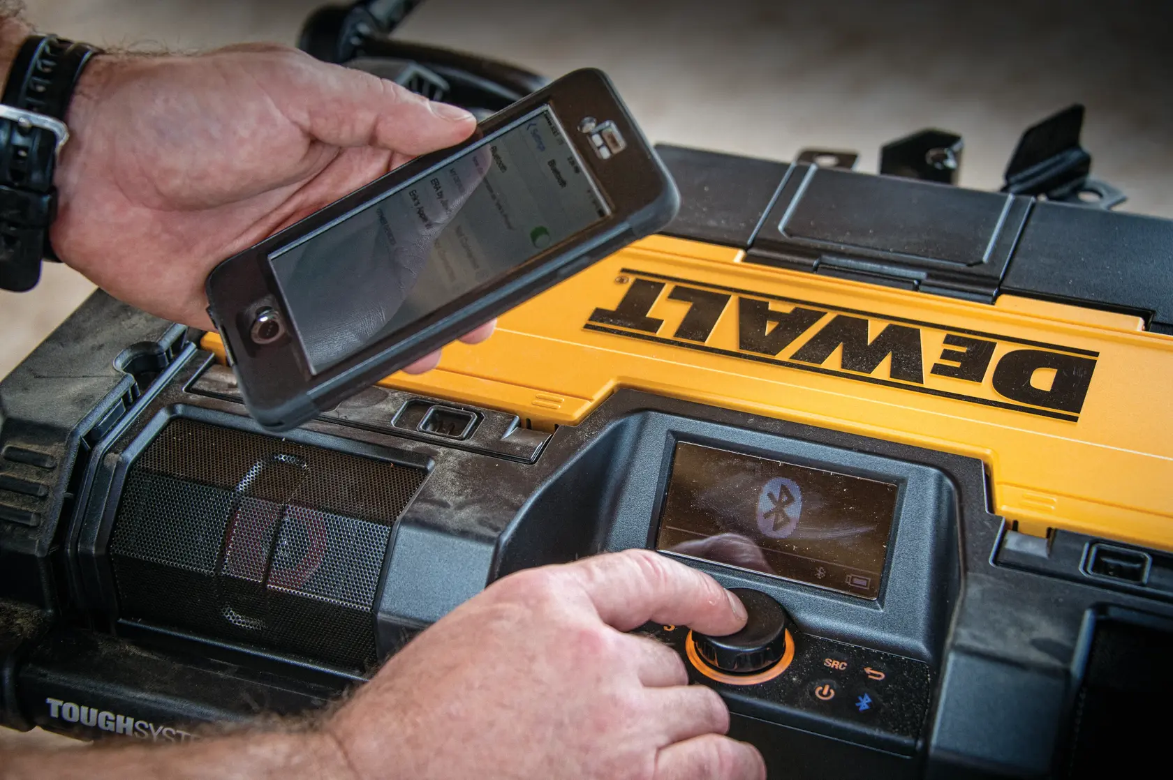 Graphique promotionnel DEWALT ToughSystem 2.0 avec le slogan 'Storage Built to Handle It' en grandes lettres jaunes sur un fond sombre texturé.